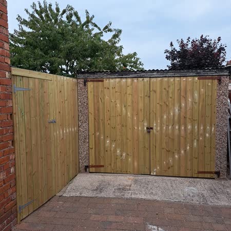 New timber double gates on a block-paved drive