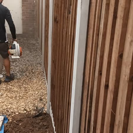 Closeboard fence and concrete posts along a driveway